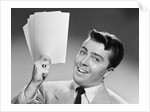 1950s Young Businessman Holding Up Handful Of Papers by Anonymous