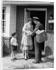 1950s Suburban Mom At Home Front Door With Son Watching Receiving Package From Mailman by Anonymous
