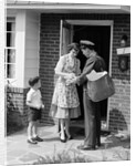 1950s Suburban Mom At Home Front Door With Son Watching Receiving Package From Mailman by Anonymous
