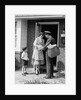 1950s Suburban Mom At Home Front Door With Son Watching Receiving Package From Mailman by Anonymous