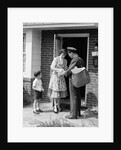 1950s Suburban Mom At Home Front Door With Son Watching Receiving Package From Mailman by Anonymous
