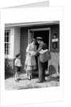 1950s Suburban Mom At Home Front Door With Son Watching Receiving Package From Mailman by Anonymous