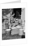 1930s Woman Farm Wife Sitting Outside Of Hen House Doorway Putting Eggs From Pails Into Shipping Crates by Anonymous