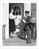 1930s Postman Giving A Letter To A Woman In The Doorway Of A Colonial Brick Home by Anonymous