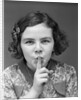 1930s Portrait Of Young Girl With Finger To Mouth Making Shush Be Quiet Expression by Anonymous