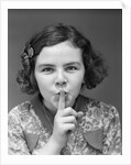 1930s Portrait Of Young Girl With Finger To Mouth Making Shush Be Quiet Expression by Anonymous