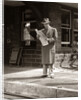 1950s Businessman On Railroad Station Platform Reading Newspaper Waiting For Train by Anonymous