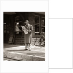 1950s Businessman On Railroad Station Platform Reading Newspaper Waiting For Train by Anonymous
