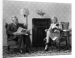 1940s Senior Couple Sitting In Living Room Reading Newspaper And Magazine Listening To Radio by Anonymous