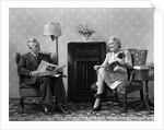 1940s Senior Couple Sitting In Living Room Reading Newspaper And Magazine Listening To Radio by Anonymous