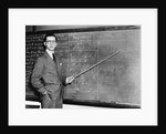 1930s Man Teacher Looking At Camera With Pointer At Blackboard by Anonymous