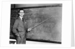 1930s Man Teacher Looking At Camera With Pointer At Blackboard by Anonymous