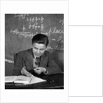 1920s 1930s Boy At Desk In Classroom In Front Of Blackboard Shooting Paper Wad With Rubber Band by Anonymous