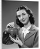 1940s Woman Putting Change Into Piggy Bank by Anonymous