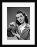 1940s Woman Putting Change Into Piggy Bank by Anonymous
