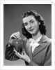 1940s Woman Putting Change Into Piggy Bank by Anonymous