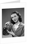 1940s Woman Putting Change Into Piggy Bank by Anonymous