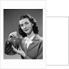 1940s Woman Putting Change Into Piggy Bank by Anonymous