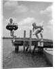 1940s 1950s Two Boys Wearing Inflatable Inner Tubes About To Jump In Lake Off Pier by Anonymous