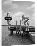 1940s 1950s Two Boys Wearing Inflatable Inner Tubes About To Jump In Lake Off Pier by Anonymous