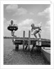 1940s 1950s Two Boys Wearing Inflatable Inner Tubes About To Jump In Lake Off Pier by Anonymous
