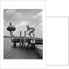 1940s 1950s Two Boys Wearing Inflatable Inner Tubes About To Jump In Lake Off Pier by Anonymous
