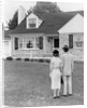 1940s 1950s Couple Standing Outside Looking At Stone Suburban House by Anonymous