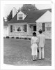1940s 1950s Couple Standing Outside Looking At Stone Suburban House by Anonymous