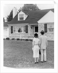 1940s 1950s Couple Standing Outside Looking At Stone Suburban House by Anonymous