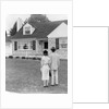 1940s 1950s Couple Standing Outside Looking At Stone Suburban House by Anonymous