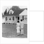 1940s 1950s Couple Standing Outside Looking At Stone Suburban House by Anonymous