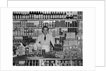 1940s Grocer Standing Behind Counter Filled With Various Food Products by Anonymous