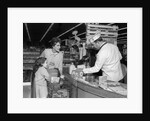 1960s Mother Daughter Unload Grocery Cart At Supermarket Checkout Counter by Anonymous
