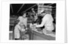 1960s Mother Daughter Unload Grocery Cart At Supermarket Checkout Counter by Anonymous