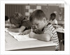 1960s Boy Striped T-Shirt Elementary School Classroom Sitting Desk Writing Test by Anonymous