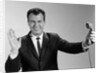 1960s Businessman Holding Telephone At Arms Length With Expression Of Disgust Or Rejection by Anonymous