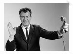 1960s Businessman Holding Telephone At Arms Length With Expression Of Disgust Or Rejection by Anonymous