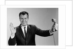 1960s Businessman Holding Telephone At Arms Length With Expression Of Disgust Or Rejection by Anonymous