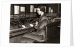 1930s Woman Telephone Operator Sitting At Large Manual Switchboard Directing Calls by Anonymous