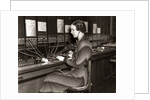 1930s Woman Telephone Operator Sitting At Large Manual Switchboard Directing Calls by Anonymous