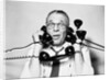 1950s 1960s Portrait Of Frazzled Businessman Trying To Answer Four Black Telephones Phones At Once by Anonymous