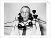 1950s 1960s Portrait Of Frazzled Businessman Trying To Answer Four Black Telephones Phones At Once by Anonymous