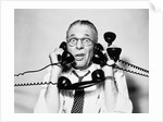 1950s 1960s Portrait Of Frazzled Businessman Trying To Answer Four Black Telephones Phones At Once by Anonymous