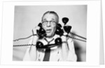 1950s 1960s Portrait Of Frazzled Businessman Trying To Answer Four Black Telephones Phones At Once by Anonymous