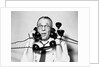 1950s 1960s Portrait Of Frazzled Businessman Trying To Answer Four Black Telephones Phones At Once by Anonymous
