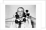 1950s 1960s Portrait Of Frazzled Businessman Trying To Answer Four Black Telephones Phones At Once by Anonymous