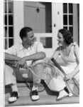 1930s Couple Man Woman In Tennis Whites Holding Racquets Sitting Talking On Steps In Front Of House Outdoor by Anonymous