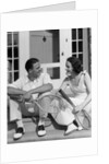1930s Couple Man Woman In Tennis Whites Holding Racquets Sitting Talking On Steps In Front Of House Outdoor by Anonymous