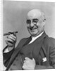 1930s Elderly Businessman In 3-Piece Suit and Glasses Leaning Back With Cigar In Hand by Anonymous
