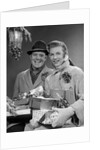 1950s Husband And Wife Carrying Armload Of Christmas Packages Standing In Snow Under Porch Light by Anonymous